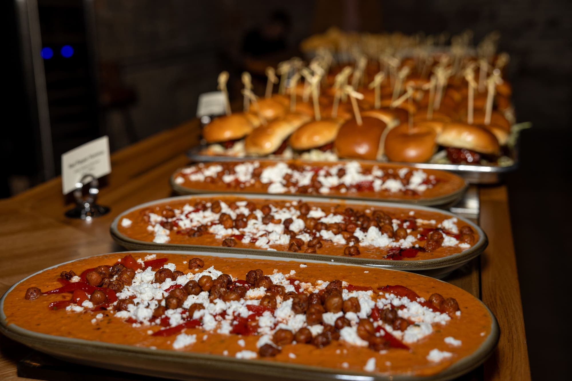 Roasted red pepper dip topped with crispy chickpeas and feta, plated for catering