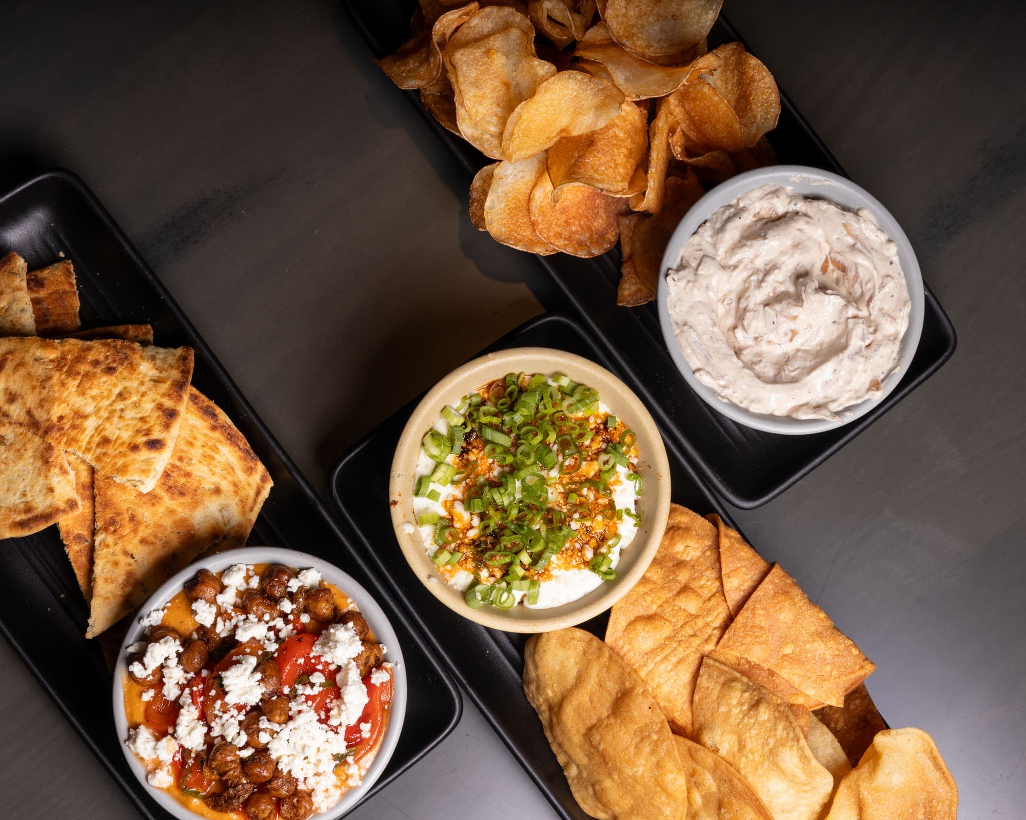 Dip trio with chips, pita, and crispy chickpeas served at a private event