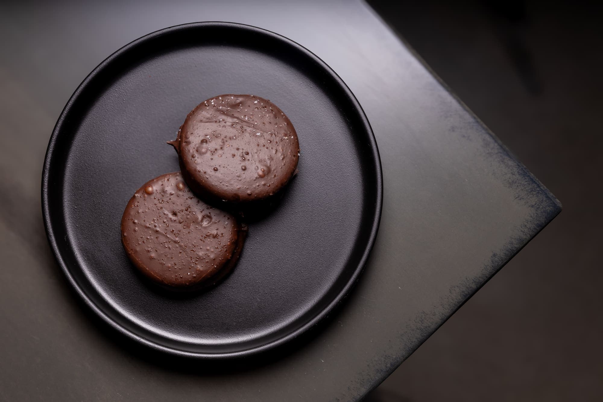 Two salted dark chocolate discs plated for a private event